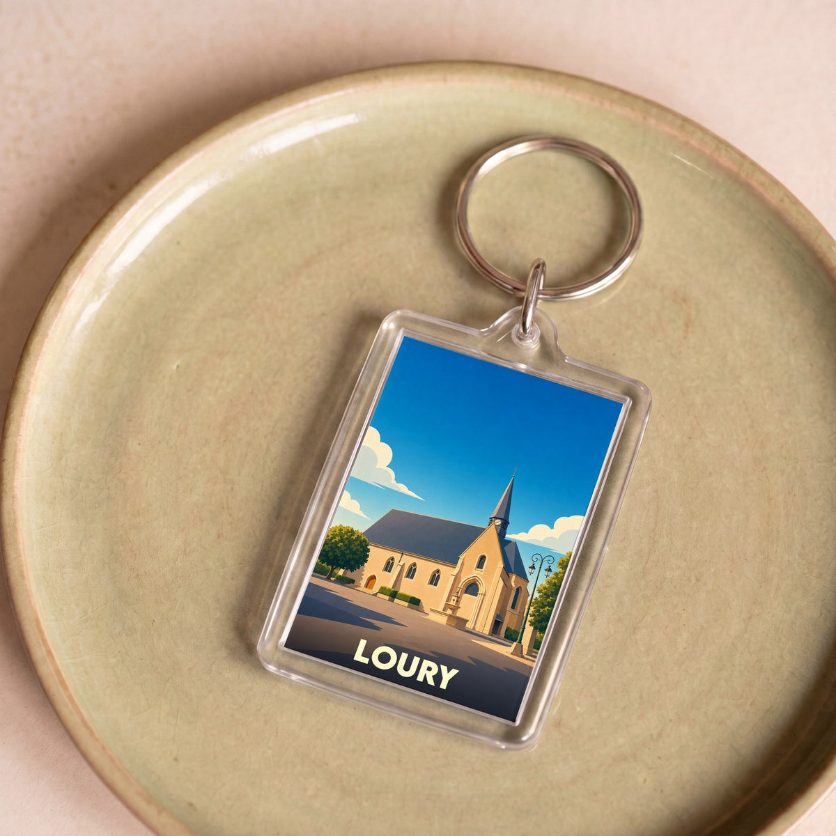 Porte-clés souvenir de la ville de Loury avec une illustration stylisée de son église.