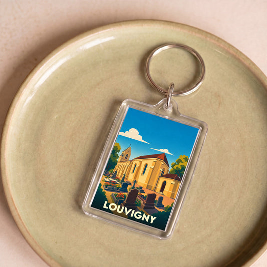 Porte-clés souvenir de la ville de Louvigny avec une illustration stylisée de son église et de son cimetière.