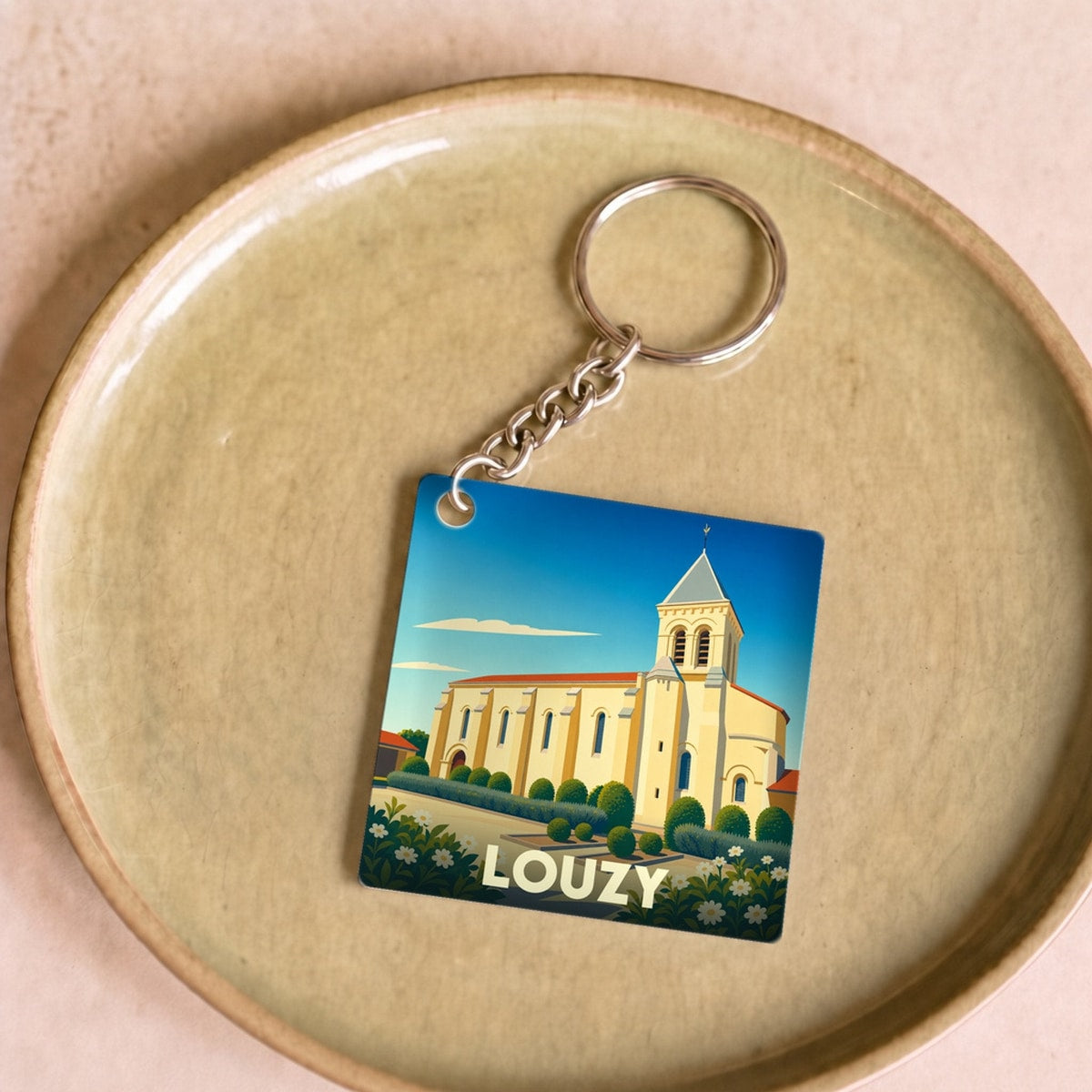 Porte-clés souvenir de la ville de Louzy avec une illustration stylisée d'une église.