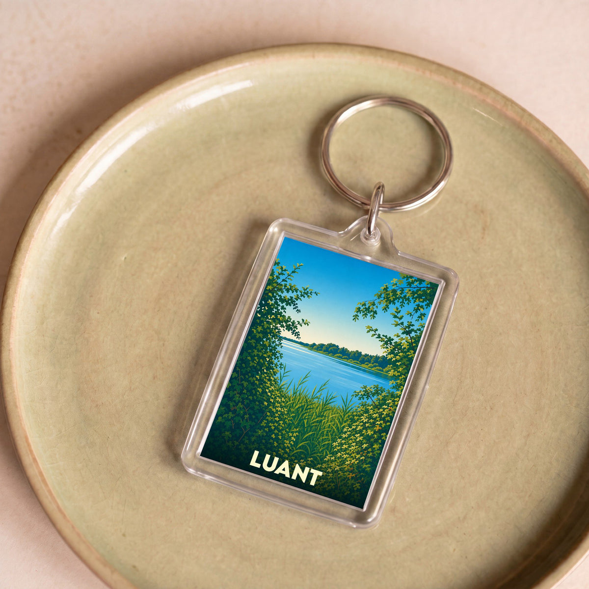 Porte-clés souvenir de la ville de Luant avec une illustration stylisée de son paysage naturel.