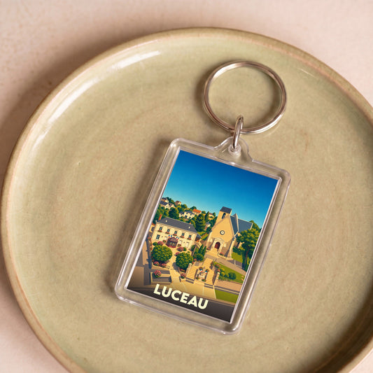 Porte-clés souvenir de la ville de Luceau avec une illustration colorée et stylisée.