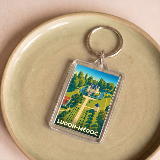 Porte-clés souvenir de la ville de Ludon-Médoc avec une illustration stylisée d'un château.