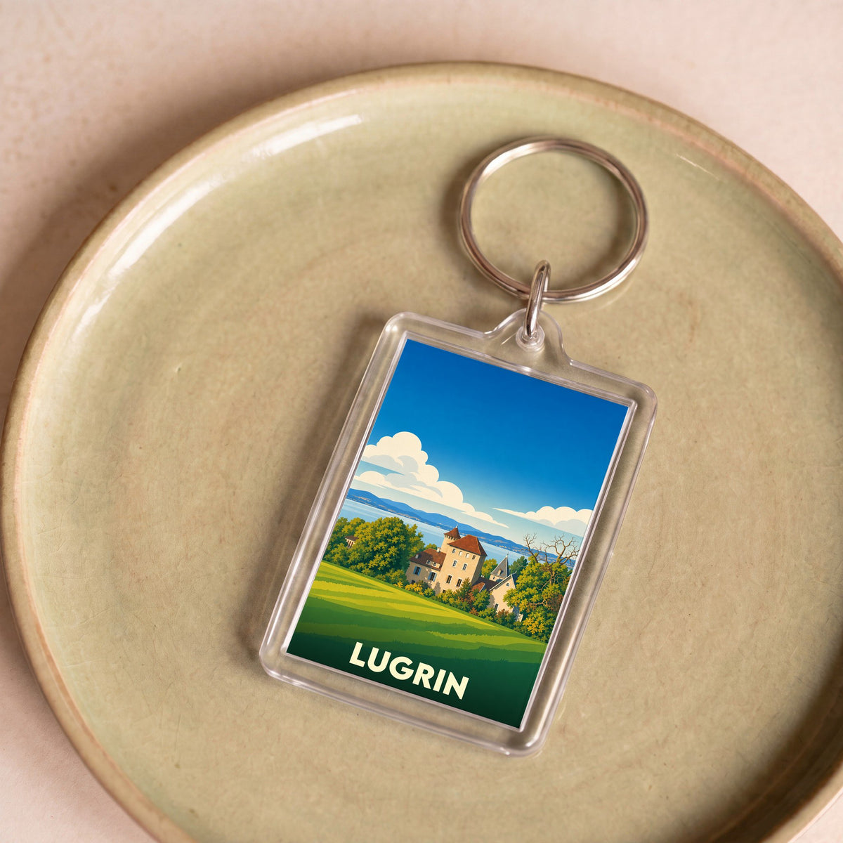 Porte-clés souvenir de la ville de Lugrin avec une illustration stylisée de son paysage et de son château.