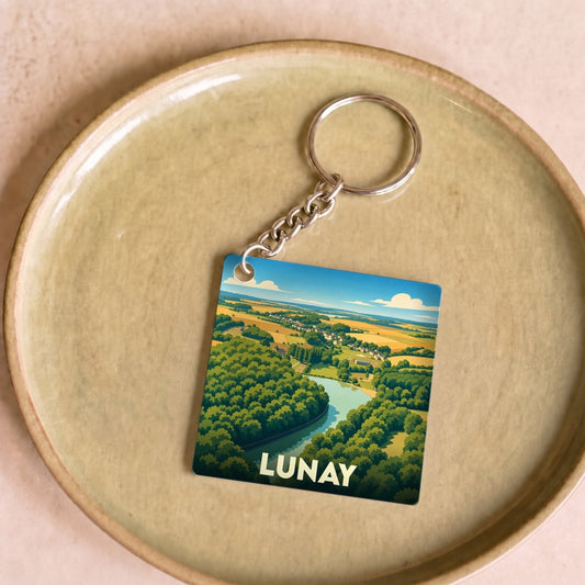 Porte-clés souvenir de la ville de Lunay avec une illustration stylisée d'un paysage de campagne et de rivière.