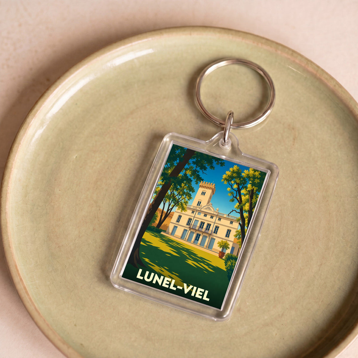 Porte-clés souvenir de la ville de Lunel-Viel avec une illustration stylisée de son château.