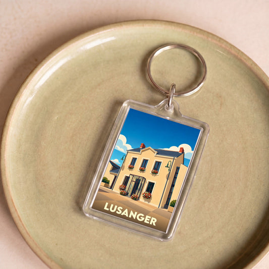 Porte-clés souvenir de la ville de Lusanger avec une illustration stylisée d'un bâtiment fleuri.