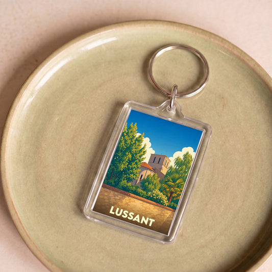 Porte-clés souvenir de la ville de Lussant avec une illustration stylisée.