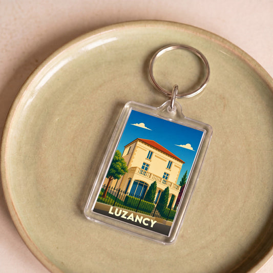 Porte-clés souvenir de la ville de Luzancy avec une illustration stylisée d'une villa.