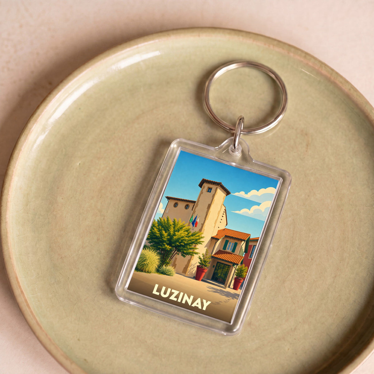 Porte-clés souvenir de la ville de Luzinay avec une illustration stylisée de son patrimoine.