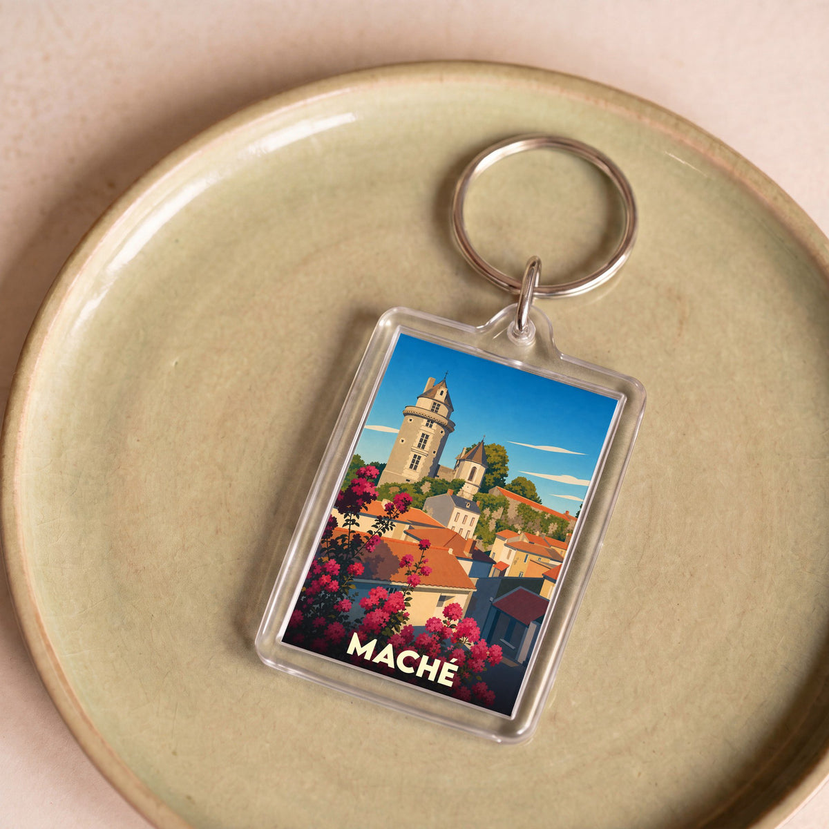 Porte-clés souvenir de la ville de Maché avec une illustration stylisée.