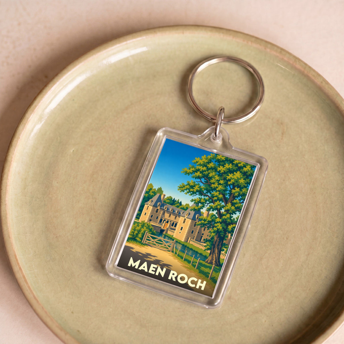 Porte-clés souvenir de la ville de Maen Roch avec une illustration stylisée d'un château.