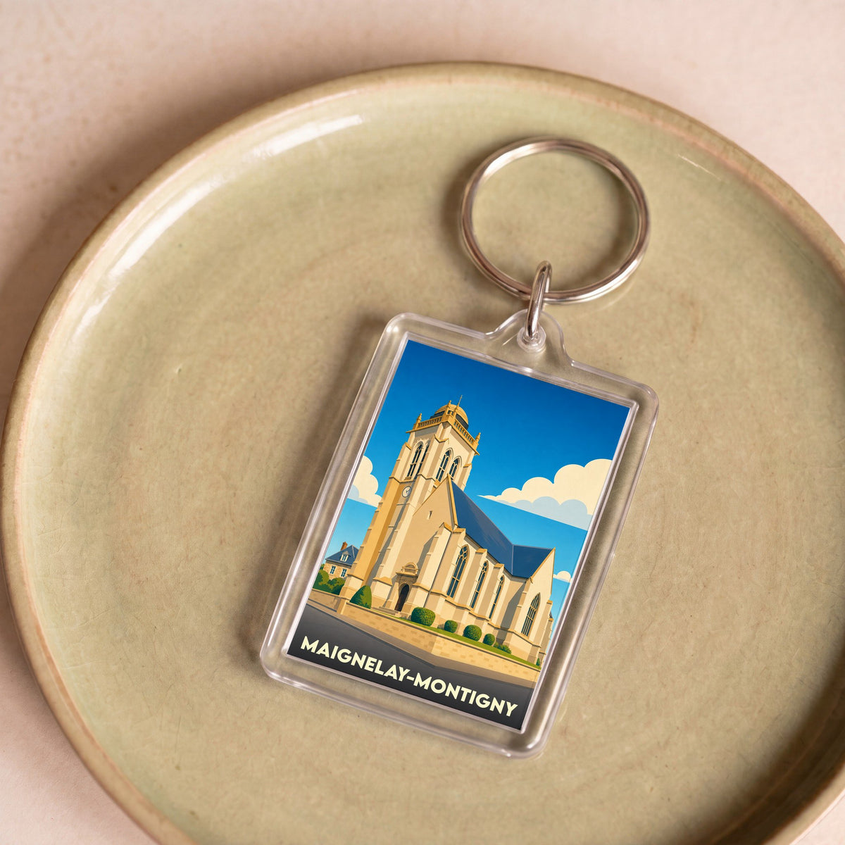 Porte-clés souvenir de la ville de Maignelay-Montigny avec une illustration stylisée de son église.