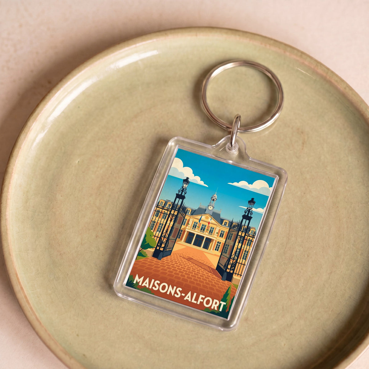 Porte-clés souvenir de la ville de Maisons-Alfort avec une illustration stylisée.