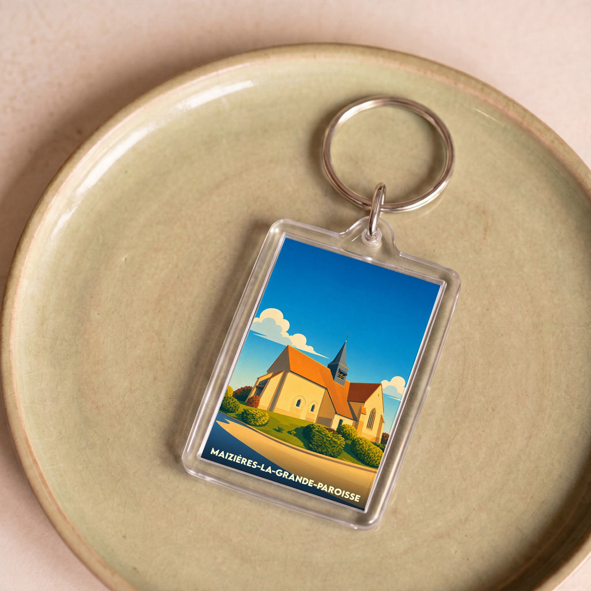 Porte-clés souvenir de la ville de Maizières-la-Grande-Paroisse avec une illustration stylisée de son église.