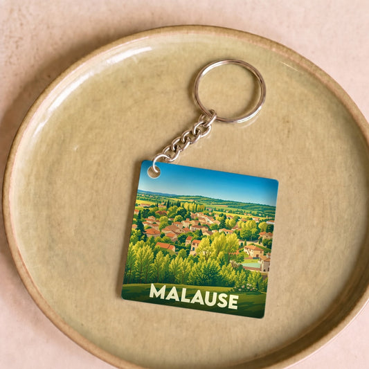 Porte-clés souvenir de la ville de Malause avec une illustration paysagère stylisée.