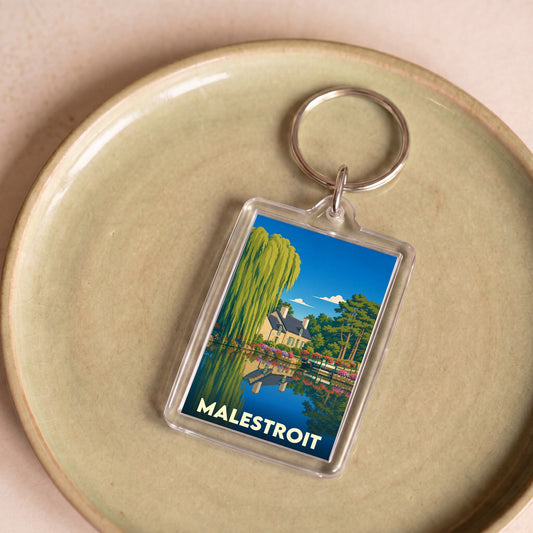 Porte-clés souvenir de la ville de Malestroit avec une illustration stylisée d'un paysage au bord de l'eau.