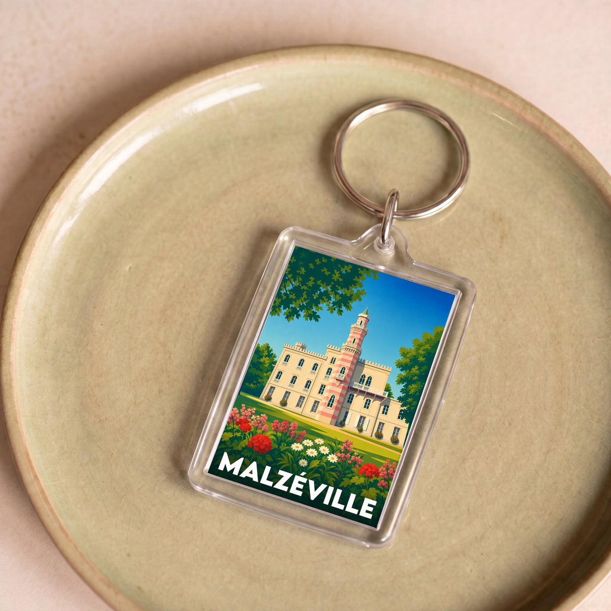 Porte-clés souvenir de la ville de Malzéville avec une illustration stylisée d'un château.