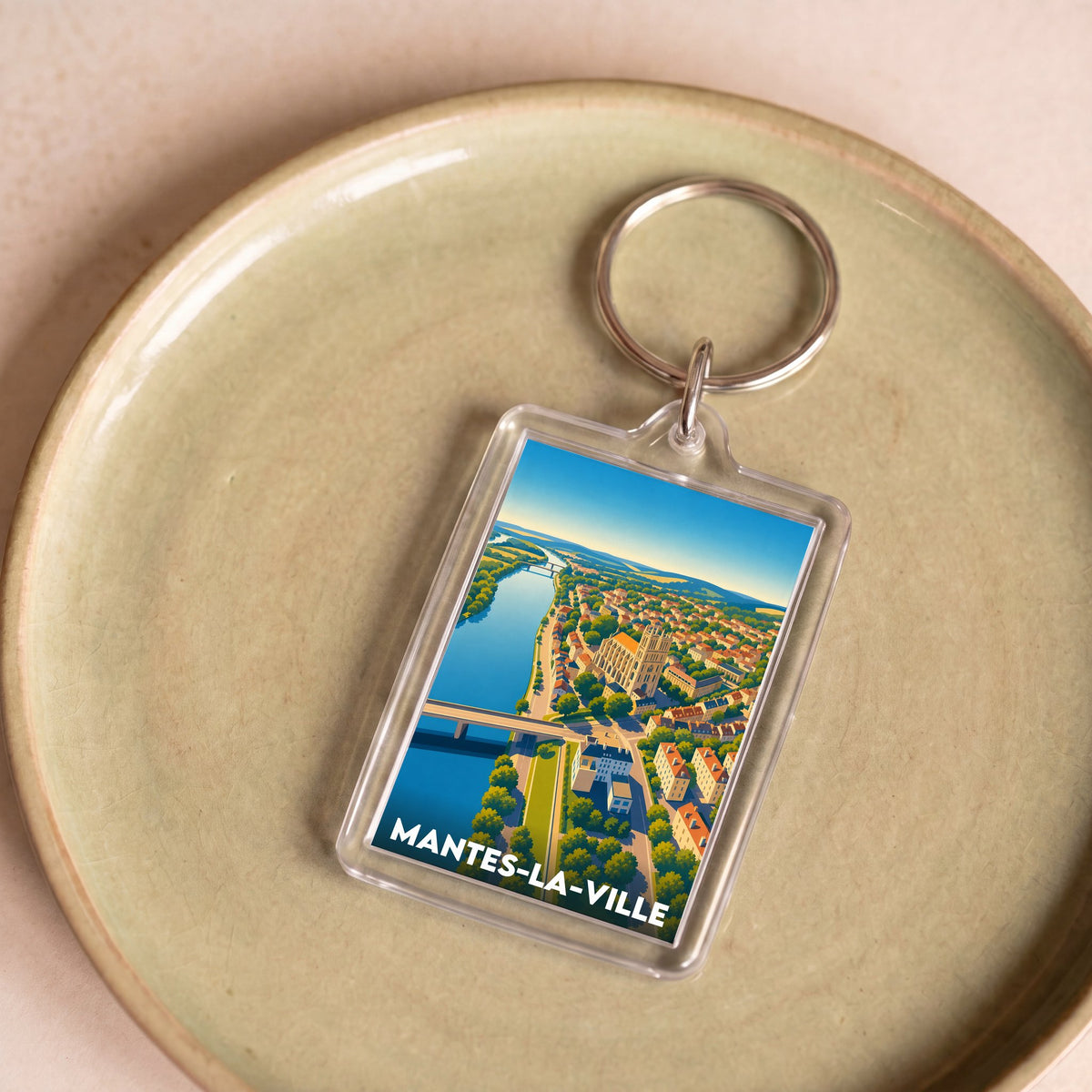Porte-clés souvenir de la ville de Mantes-la-Ville avec une illustration stylisée.