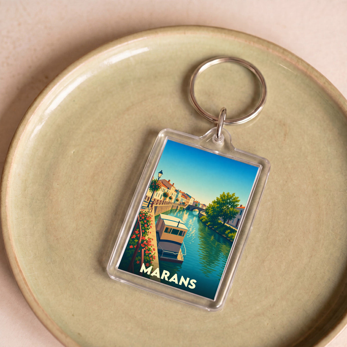 Porte-clés souvenir de la ville de Marans avec une illustration stylisée de ses canaux.