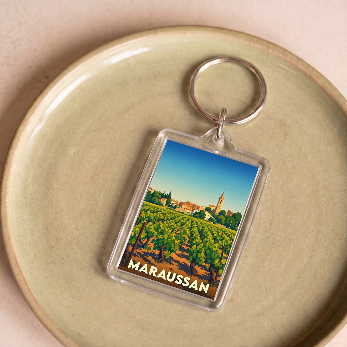 Porte-clés souvenir de la ville de Maraussan avec une illustration stylisée de ses vignobles.