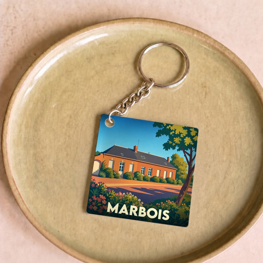 Porte-clés souvenir de la ville de Marbois avec une illustration stylisée d'une demeure traditionnelle.