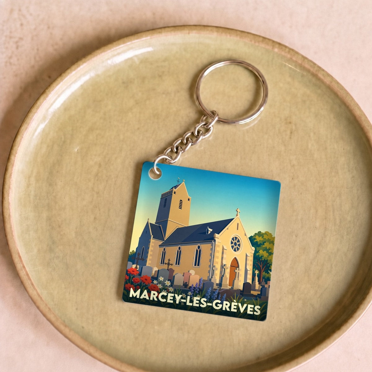 Porte-clés souvenir de la ville de Marcey-les-Grèves avec une illustration stylisée de son église.