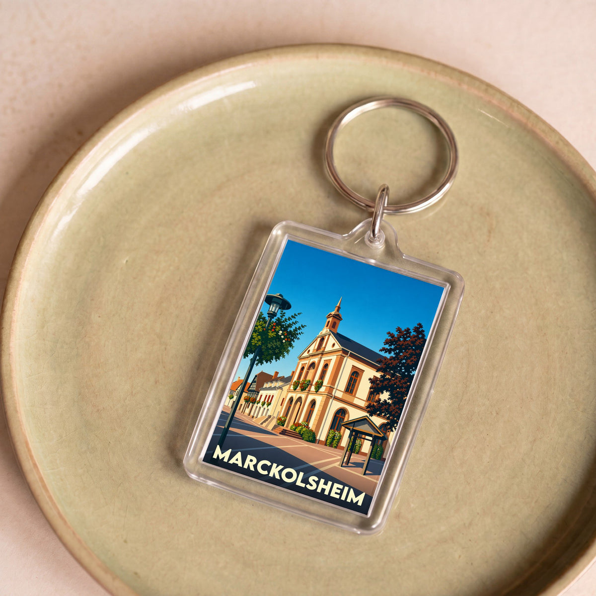 Porte-clés souvenir de la ville de Marckolsheim avec une illustration stylisée.