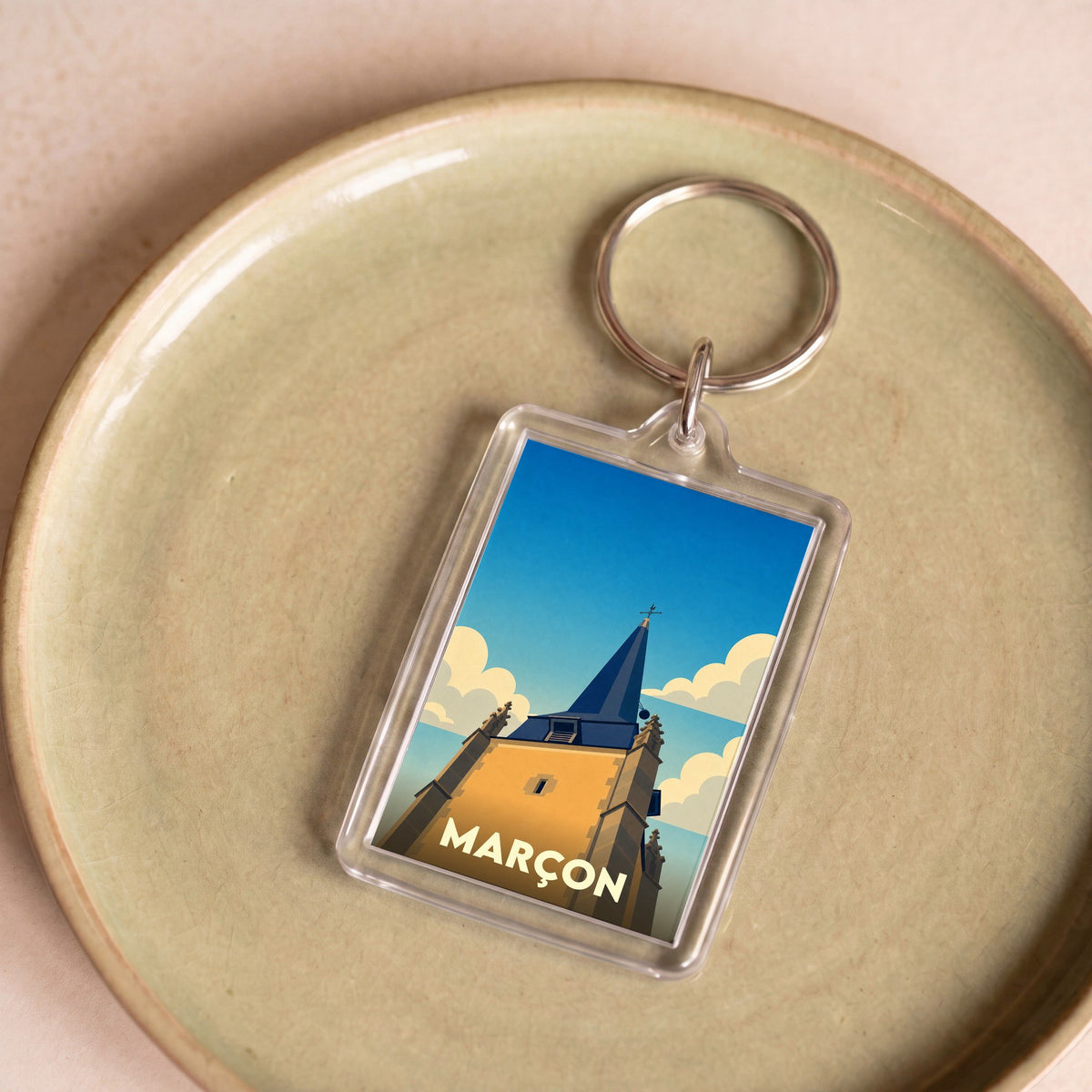 Porte-clés souvenir de la ville de Marçon avec une illustration stylisée de son clocher.