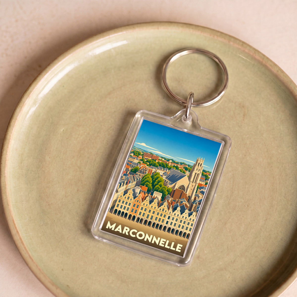 Porte-clés souvenir de la ville de Marconnelle avec une illustration stylisée de son architecture.