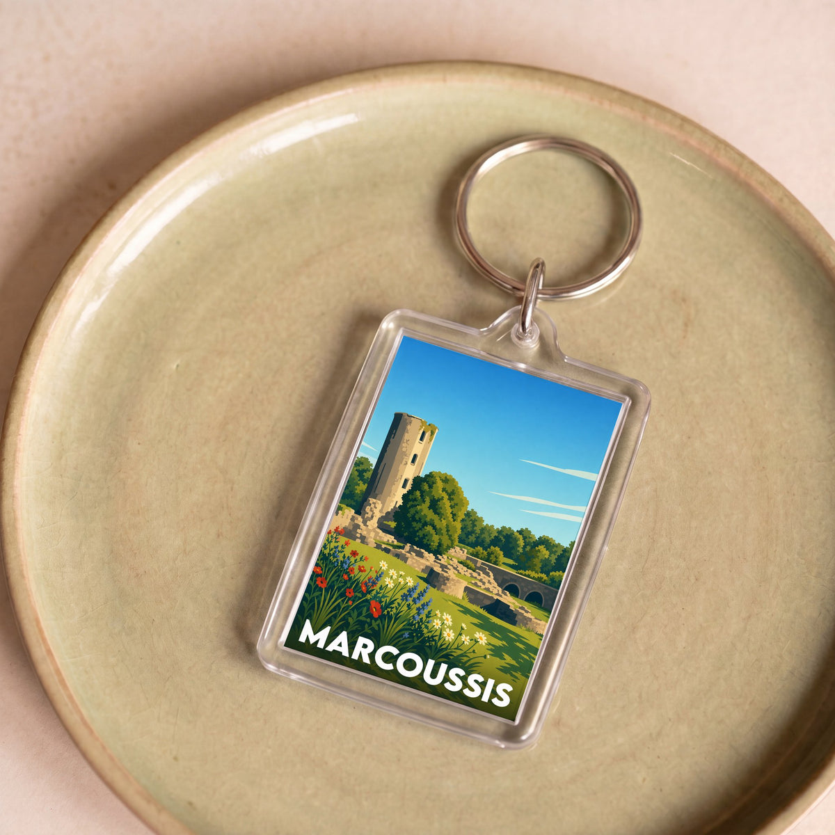 Porte-clés souvenir de la ville de Marcoussis avec une illustration stylisée d'un paysage historique.