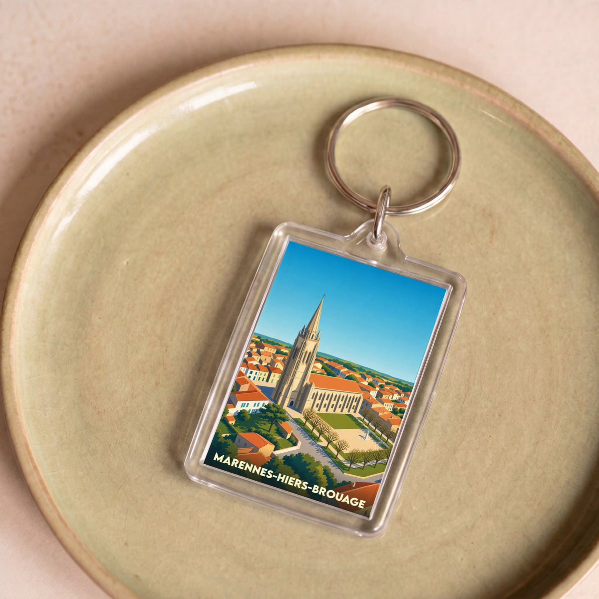 Porte-clés souvenir de la ville de Marennes-Hiers-Brouage avec une illustration stylisée de son église.