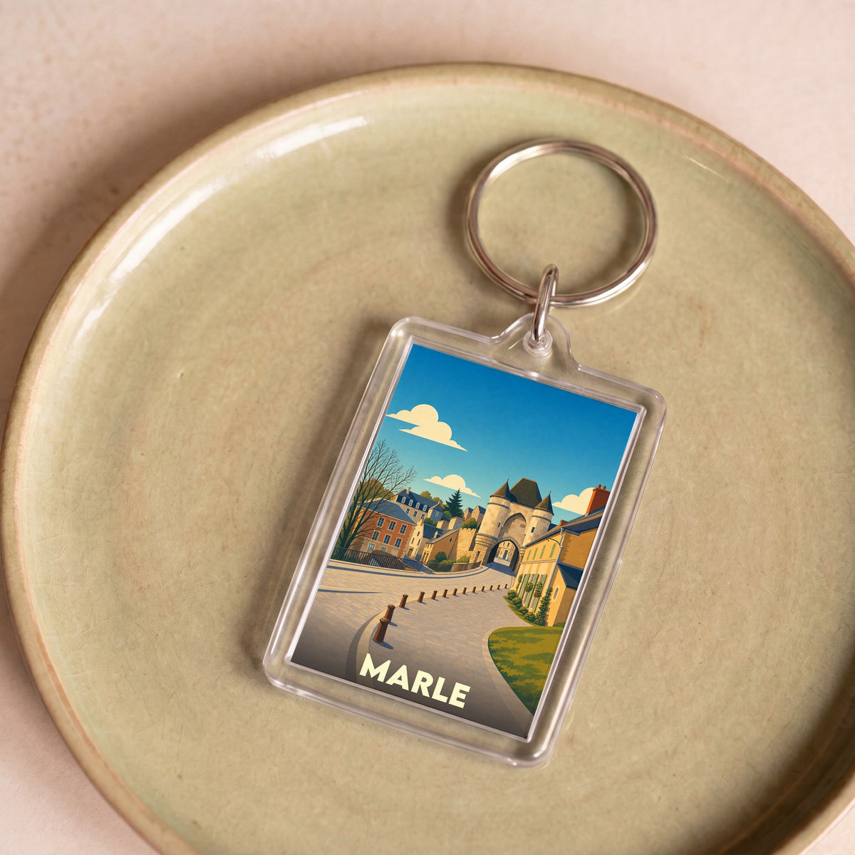 Porte-clés souvenir de la ville de Marle avec une illustration stylisée de ses bâtiments historiques.