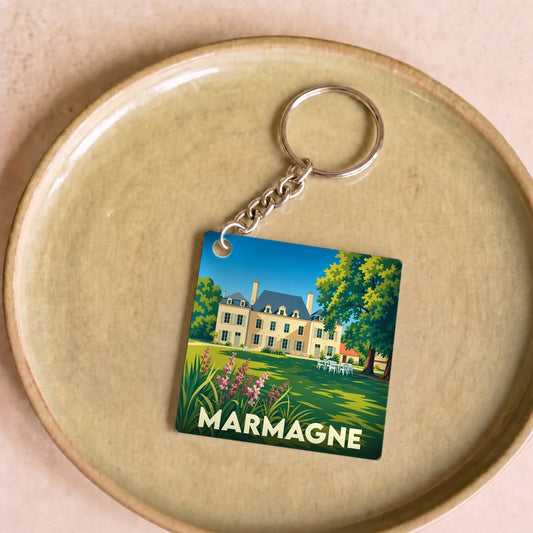 Porte-clés souvenir de la ville de Marmagne avec une illustration stylisée d'une demeure bourgeoise et son jardin.