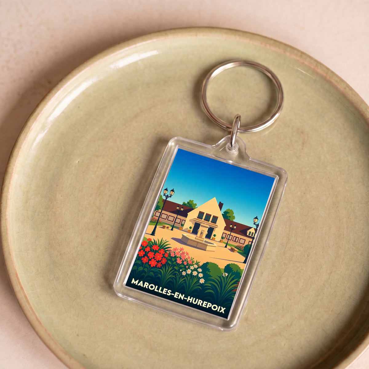 Porte-clés souvenir de la ville de Marolles-en-Hurepoix avec une illustration stylisée.