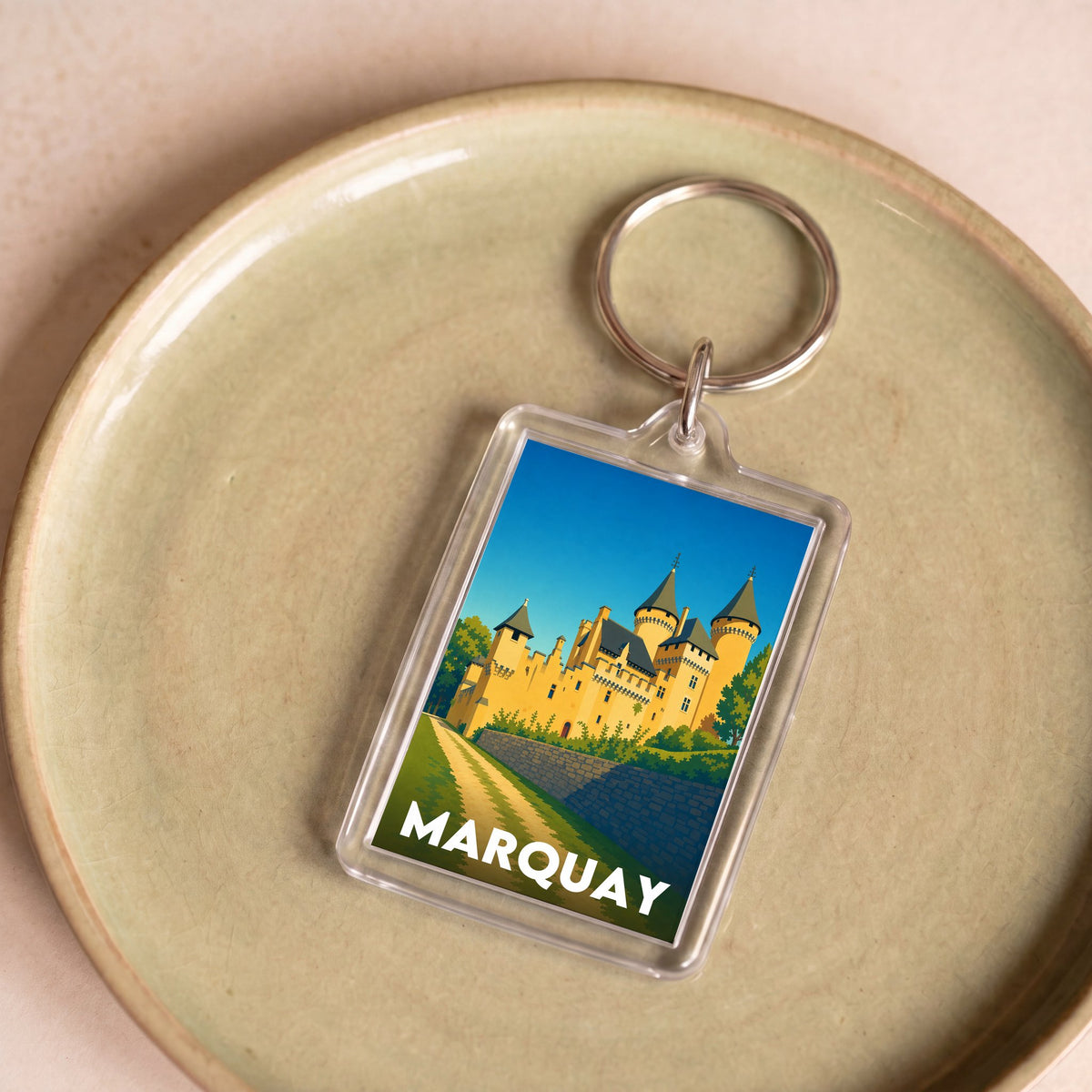 Porte-clés souvenir de la ville de Marquay avec une illustration stylisée d'un château.