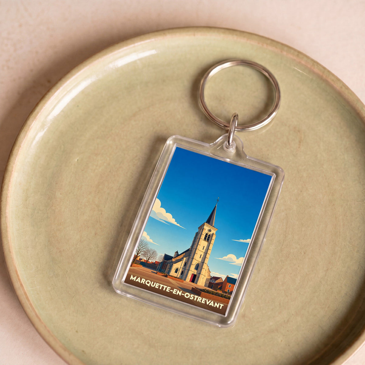 Porte-clés souvenir de la ville de Marquette-en-Ostrevant avec une illustration stylisée de son église.