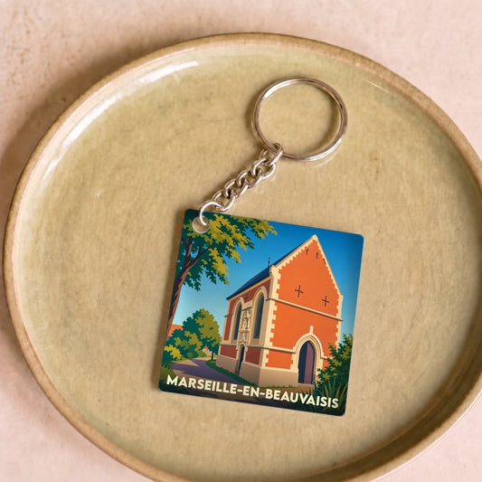 Porte-clés souvenir de la ville de Marseille-en-Beauvaisis avec une illustration stylisée d'une église.