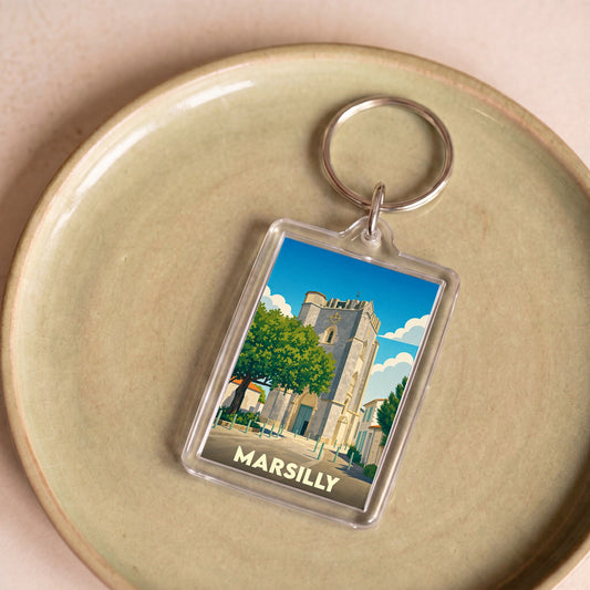 Porte-clés souvenir de la ville de Marsilly avec une illustration stylisée de son église fortifiée.