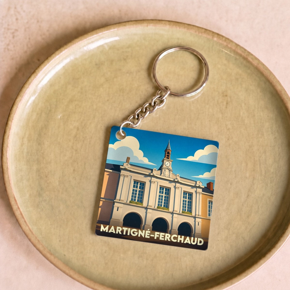 Porte-clés souvenir de la ville de Martigné-Ferchaud avec une illustration stylisée.