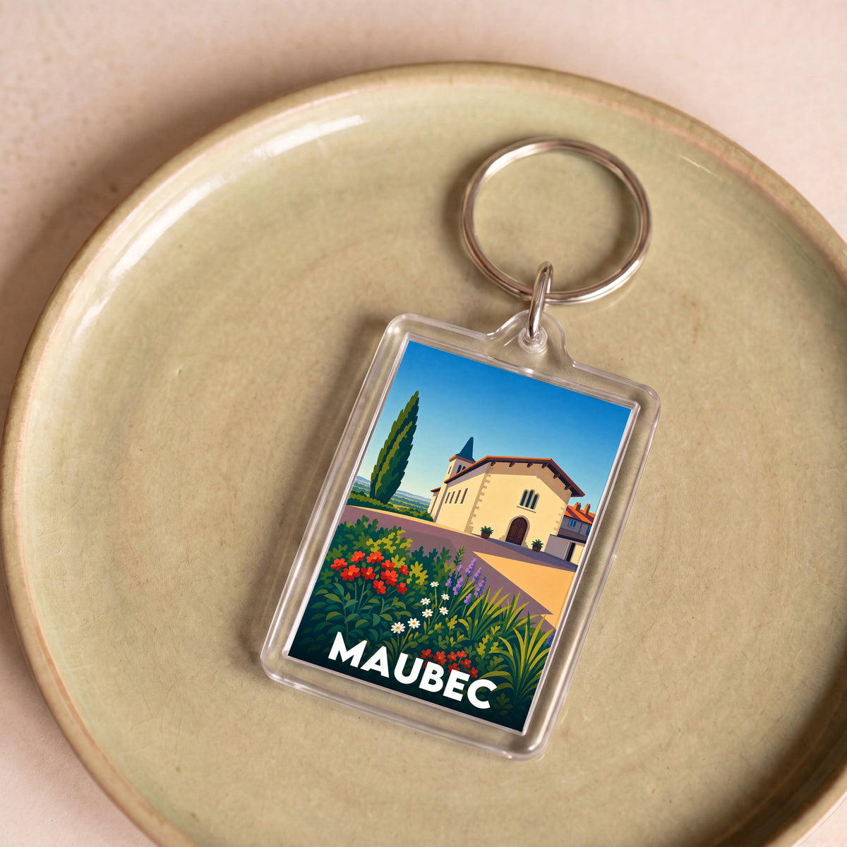 Porte-clés souvenir de la ville de Maubec avec une illustration stylisée et colorée.