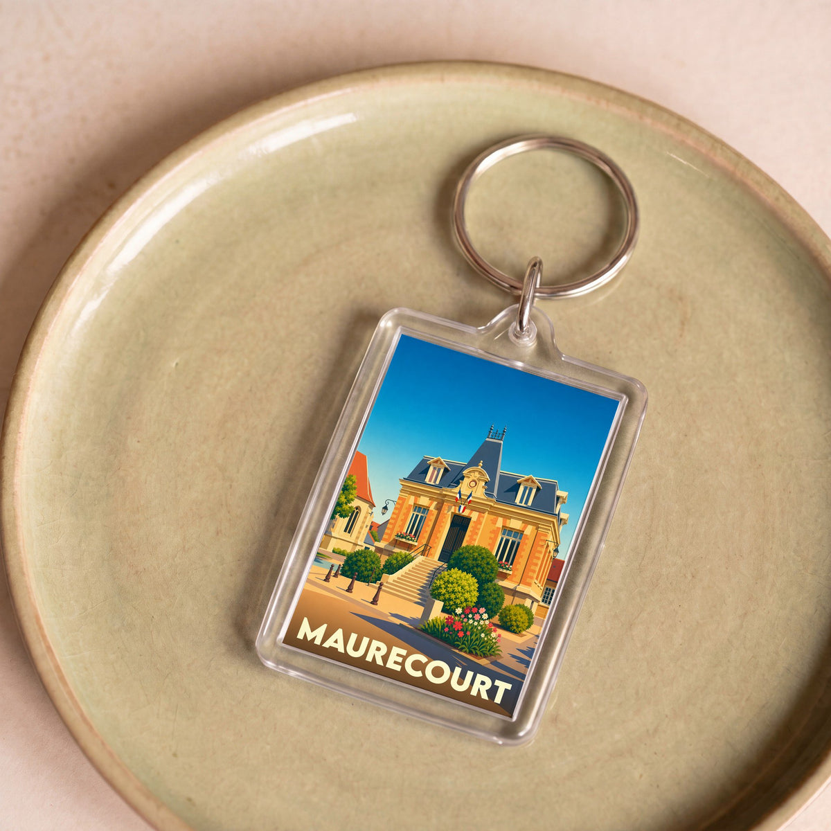 Porte-clés souvenir de la ville de Maurecourt avec une illustration stylisée de son hôtel de ville.