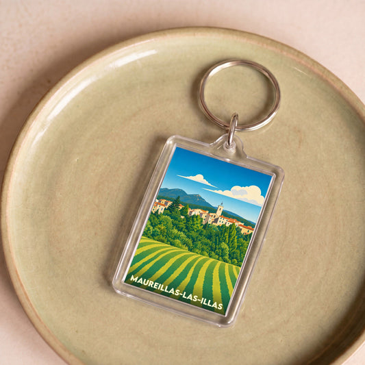 Porte-clés souvenir de la ville de Maureillas-las-Illas avec une illustration stylisée de son paysage.