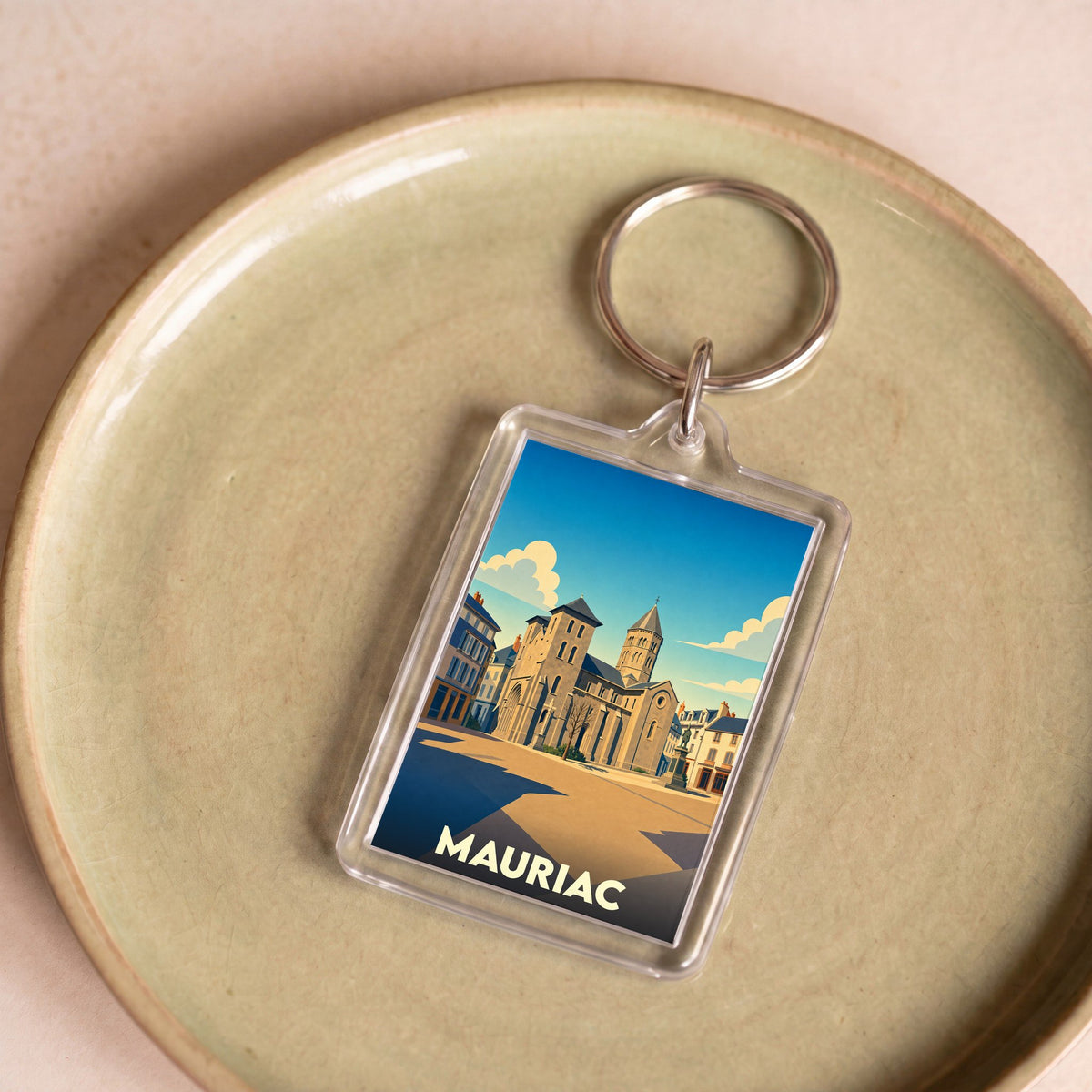 Porte-clés souvenir de la ville de Mauriac avec une illustration stylisée.