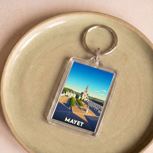 Porte-clés souvenir de la ville de Mayet avec une illustration stylisée d'une place ensoleillée.