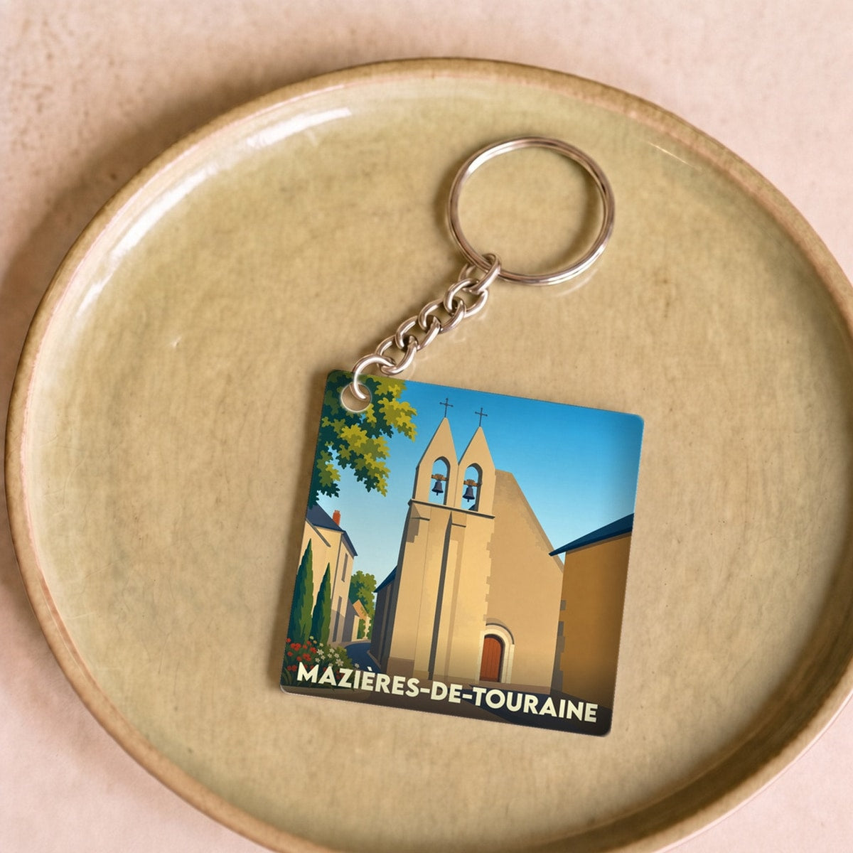 Porte-clés souvenir de la ville de Mazières-de-Touraine avec une illustration stylisée de son église.