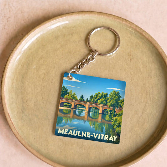 Porte-clés souvenir de la ville de Meaulne-Vitray avec une illustration stylisée d'un pont sur une rivière.