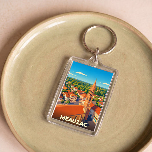 Porte-clés souvenir de la ville de Meauzac avec une illustration stylisée.