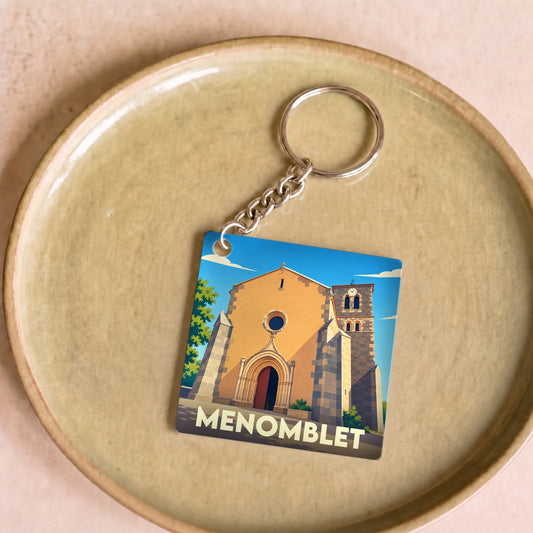 Porte-clés souvenir de la ville de Menomblet avec une illustration stylisée de son église.