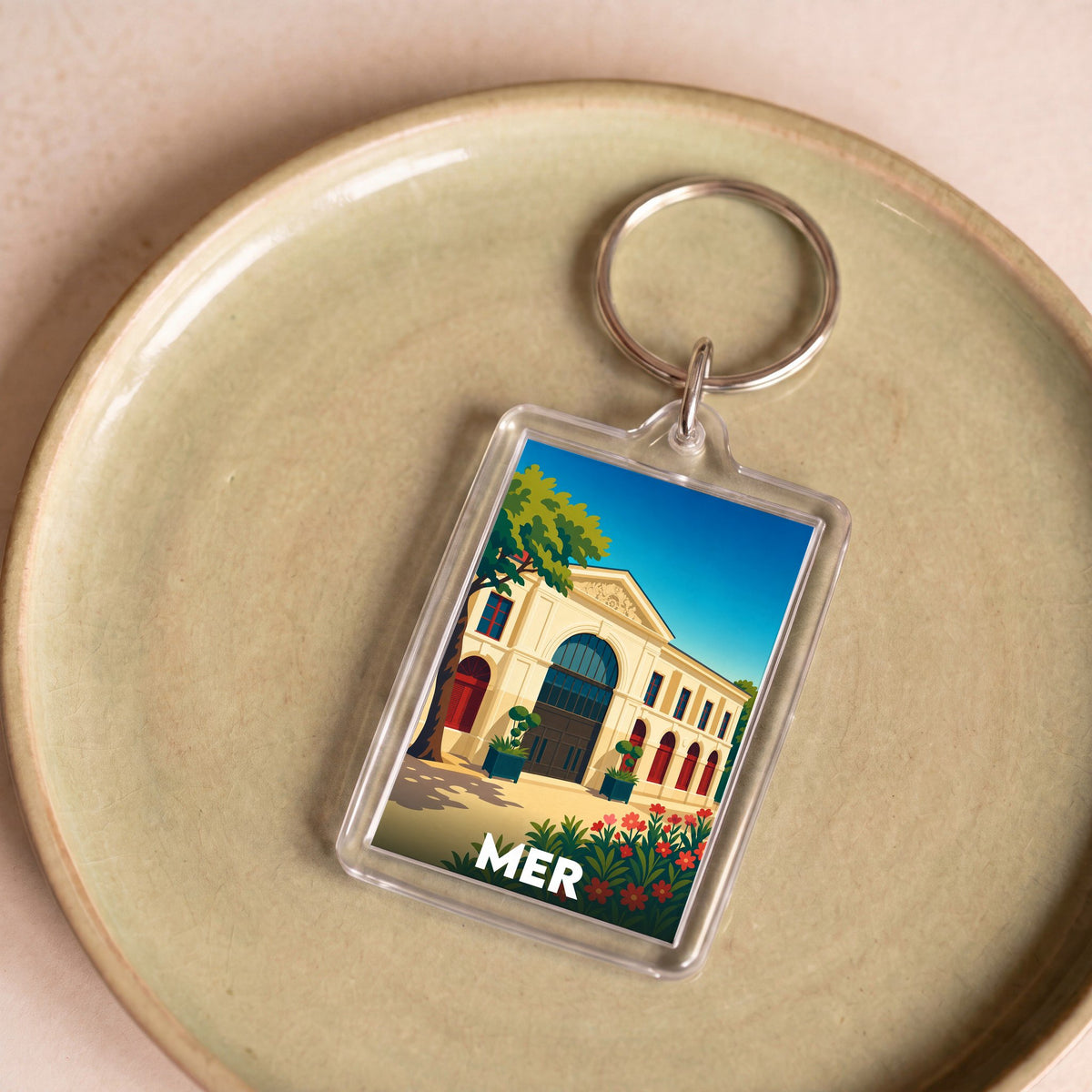 Porte-clés souvenir de la ville de Mer avec une illustration stylisée d'un bâtiment historique.