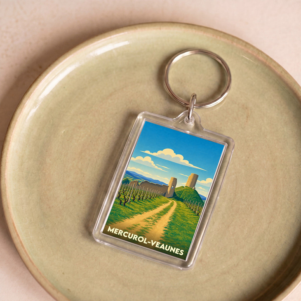 Porte-clés souvenir de la ville de Mercurol-Veaunes avec une illustration stylisée de ses paysages et châteaux.